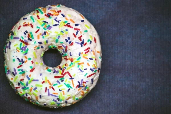 Close-up donut branco em um espaço de cópia de fundo azul escuro — Fotografia de Stock