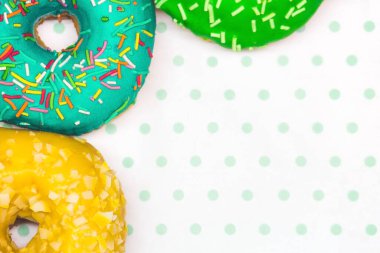 Beyaz-yeşil arkaplan kopyalama alanına çok renkli çörekler yakın plan