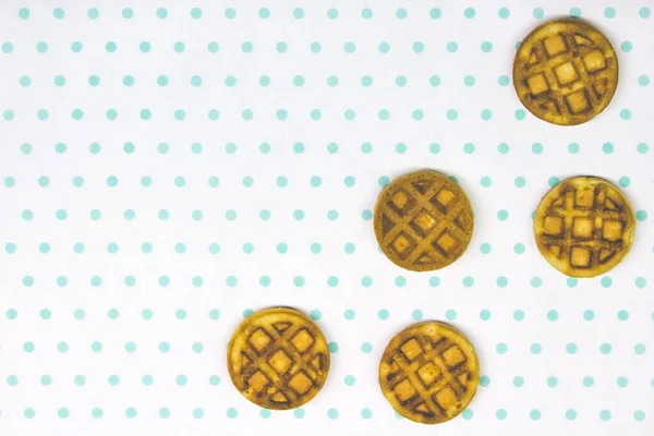 Beyaz turkuaz arka plan kopyalama alanı üzerinde fırınlanmış yuvarlak waffle 'lar