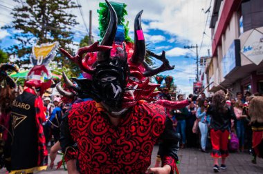 PILLARO, ECUADOR - JANUARY 3, 2020: Person in a red devil mask at the Diablada or Devil Festival