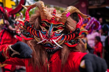 PILLARO, ECUADOR - JANUARY 3, 2020: Person in a red devil mask at the Diablada or Devil Festival