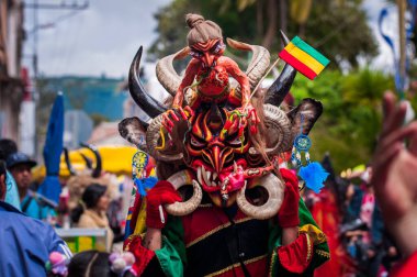 PILLARO, ECUADOR - JANUARY 3, 2020: Person in a red devil mask at the Diablada or Devil Festival