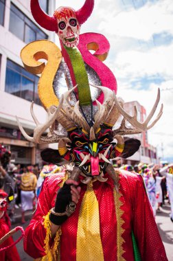 PILLARO, ECUADOR - JANUARY 3, 2020: Person in a red devil mask at the Diablada or Devil Festival