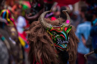 PILLARO, ECUADOR - JANUARY 3, 2020: Person in a red devil mask at the Diablada or Devil Festival