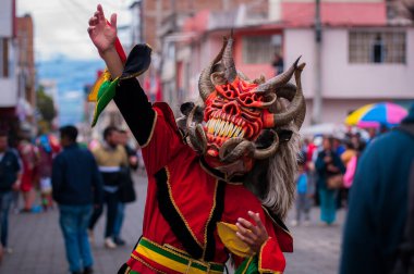 PILLARO, ECUADOR - JANUARY 3, 2020: Person in a red devil mask at the Diablada or Devil Festival
