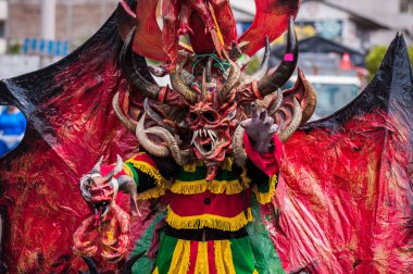 PILLARO, ECUADOR - JANUARY 3, 2020: Person in a red devil mask at the Diablada or Devil Festival
