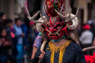 PILLARO, ECUADOR - JANUARY 3, 2020: Person in a red devil mask at the Diablada or Devil Festival