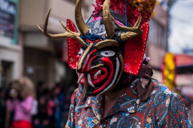 PILLARO, ECUADOR - JANUARY 3, 2020: Person in a red devil mask at the Diablada or Devil Festival