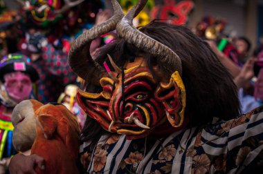 PILLARO, ECUADOR - JANUARY 3, 2020: Person in a red devil mask at the Diablada or Devil Festival