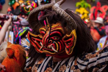 PILLARO, ECUADOR - JANUARY 3, 2020: Person in a red devil mask at the Diablada or Devil Festival