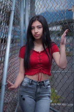 Üzgün bakışlı, uzun siyah saçlı, parkın ortasında depresif bir kız.