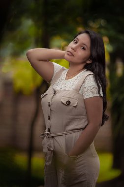 Ormanın ortasında duran genç bir kadın. Karanlık bir ton.