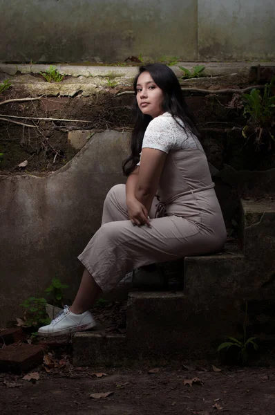 公園の崩壊した漂白剤に座っている若い女性の肖像画 — ストック写真