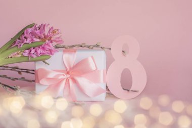 Pembe kurdeleli beyaz hediye kutusu, sümbül çiçeği, vajina söğüt dalları ve ışık efektli pastel pembe arka planda 8 numara. Uluslararası Kadınlar Günü 'nüz kutlu olsun 8 Mart tebrik kartı. Boşluğu kopyala.
