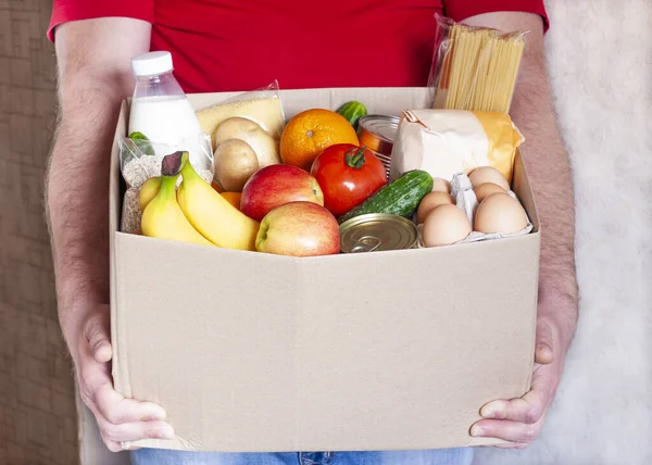 Mensajero Entrega Comestibles Uniforme Rojo Sostiene Caja Cartón Con Verduras —  Fotos de Stock