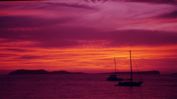 Пост заходу сонця після сяйва в морі з припаркованими вітрильними човнами — стокове відео