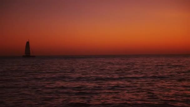 Парусная лодка на море после заката — стоковое видео