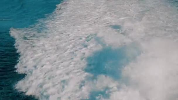 Sendero de olas espumosas que quedan en el mar desde el motor del barco traveilng — Vídeos de Stock