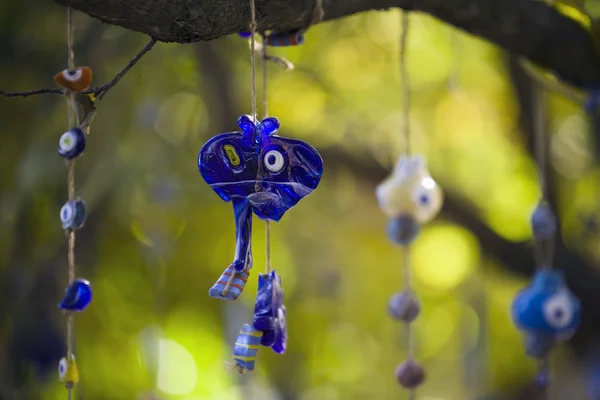 Amuleto azul pendurado em uma árvore . — Fotografia de Stock