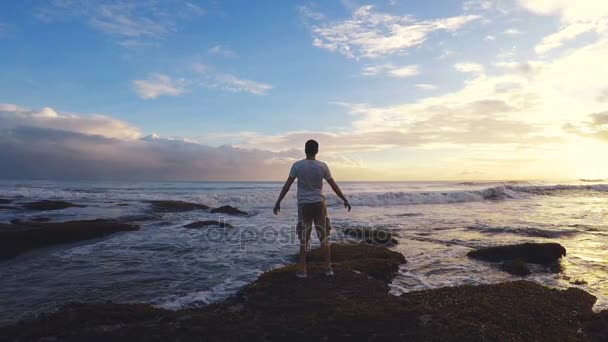 20s man opening his arms up towards the ocean. — Stock Video