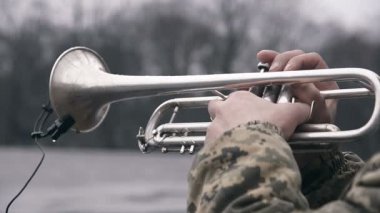 Sokak müzisyeni askeri Kamuflaj ceketi ile oynarken trompet.