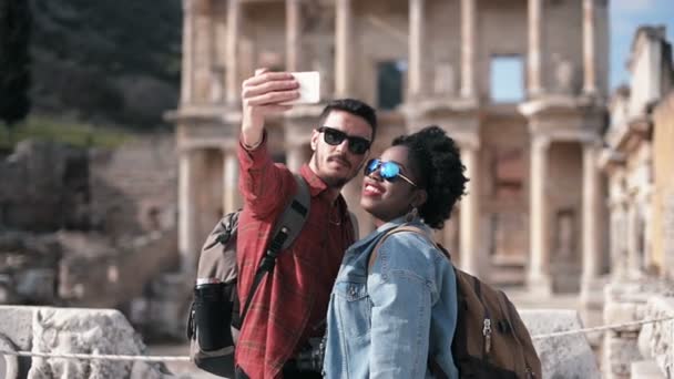 Vit Och Afrikanska Par Tar Selfie Framför Det Celcus Biblioteket — Stockvideo