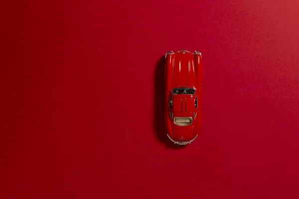 Красный цвет игрушки модель автомобиля продукт снят на красном фоне . — стоковое фото