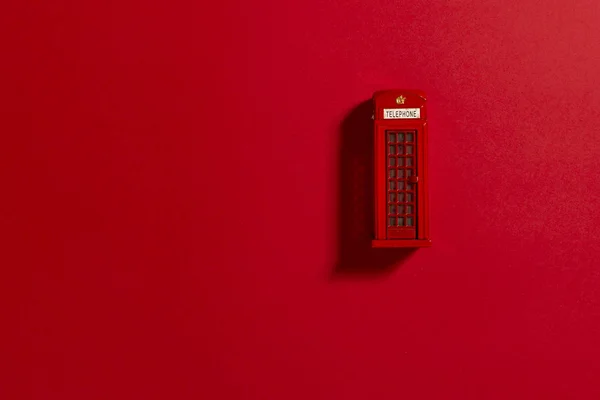 Red phone box on a red background.