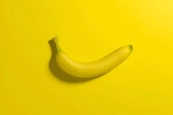 Jeden banan na żółtym tle. — Zdjęcie stockowe