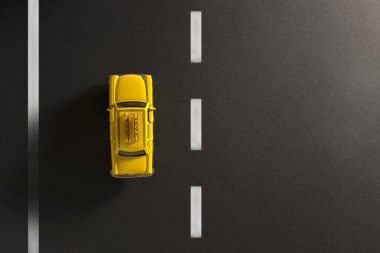 Siyah bir zemin üzerine sarı taksi.