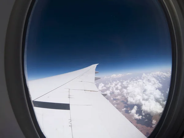 Πτέρυγα του αεροσκάφους και τα σύννεφα πάνω από τη γη. — Φωτογραφία Αρχείου