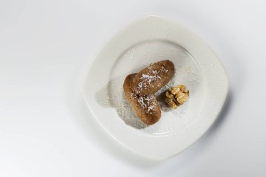 Bilenmiş yumurta şekilli tatlı hamur işleri beyaz tabakta ve bir whit üzerinde