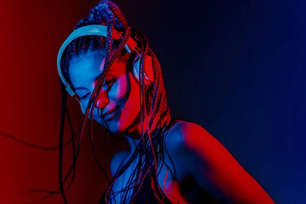 Dj mujer con el pelo trenzado árbol y bailando con auriculares . —  Fotos de Stock