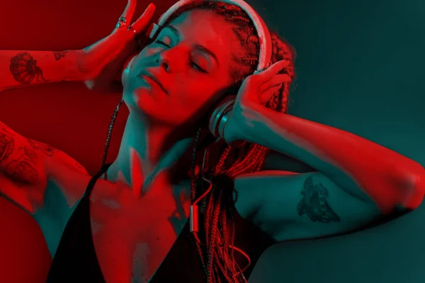 Dj mujer con el pelo trenzado árbol y bailando con auriculares . —  Fotos de Stock