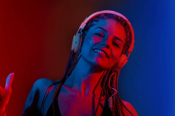 Dj mujer con el pelo trenzado árbol y bailando con auriculares . —  Fotos de Stock