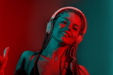 Ağaç örgülü saçlı ve kulaklıkla dans eden DJ kadın..