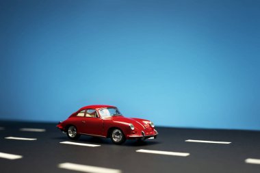 Porsche Carrera 'nın yan görüntüsü. Mavi bir sırt çantasındaki 2 oyuncak araba.