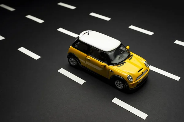 Vista superior superior de um carro amarelo Mini Cooper S Toy em backg amarelo — Fotografia de Stock