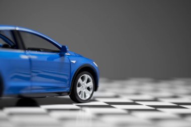 Mavi bir Tesla Modeli 'nin yan görüntüsü Bir kasada 90d oyuncak araba