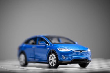 Mavi bir Tesla Modeli 'nin ön görüntüsü. Çekin üzerinde 90d oyuncak araba.