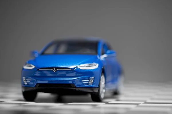 Front view of a blue Tesla Model x 90D toy model car on a cheque — Stock Photo, Image