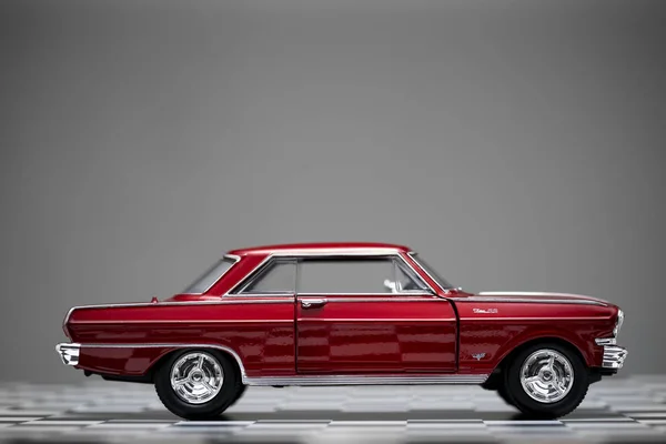 Zijaanzicht van een rood gekleurde 1960 Chevrolet Nova speelgoed model auto. — Stockfoto