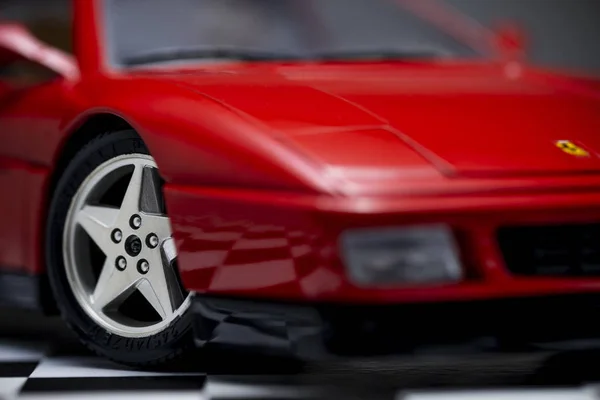 Rood speelgoed Ferrari 348tb sportwagen close-up product schot op een wang — Stockfoto