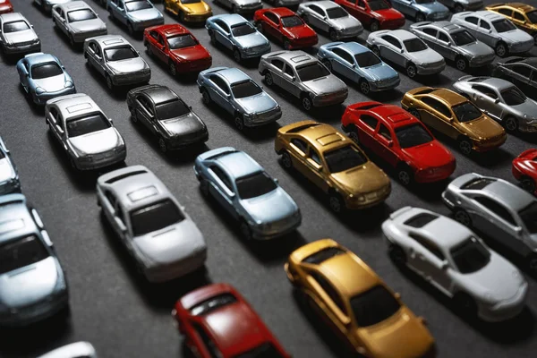 Parked toy cars on a black background like a car parking lot. — Stock Photo, Image