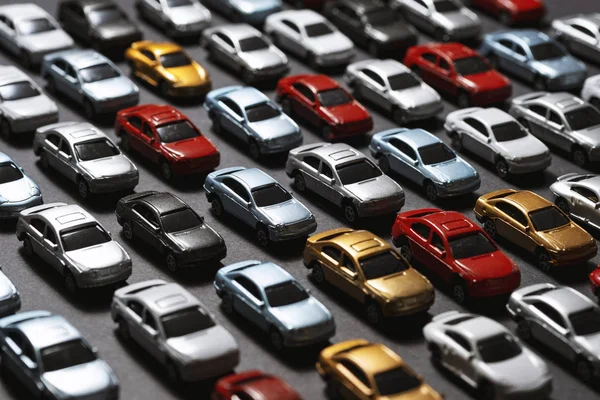 Carros de brinquedo estacionados em um fundo preto como um estacionamento de carro . — Fotografia de Stock