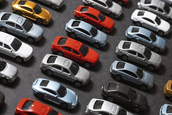 Carros de brinquedo estacionados em um fundo preto como um estacionamento de carro . — Fotografia de Stock