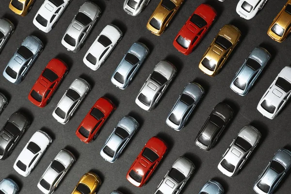 Geparkte Spielzeugautos auf schwarzem Hintergrund wie ein Parkplatz. — Stockfoto