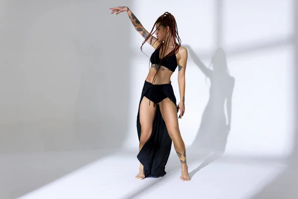 Negro vestido y trenzado mujer de pelo con tatuajes bailando en una w —  Fotos de Stock