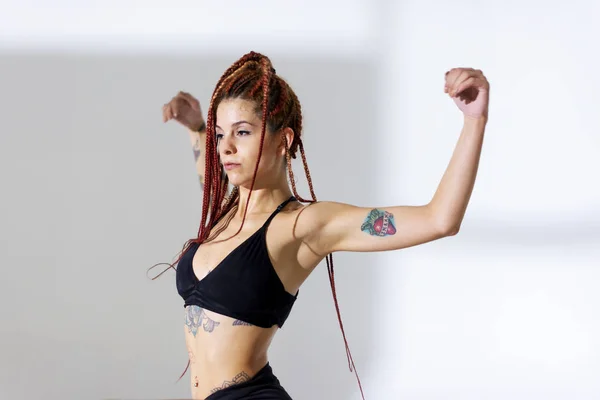 Black dressed and braided hair woman with tattoos dancing on a w — Stock Photo, Image