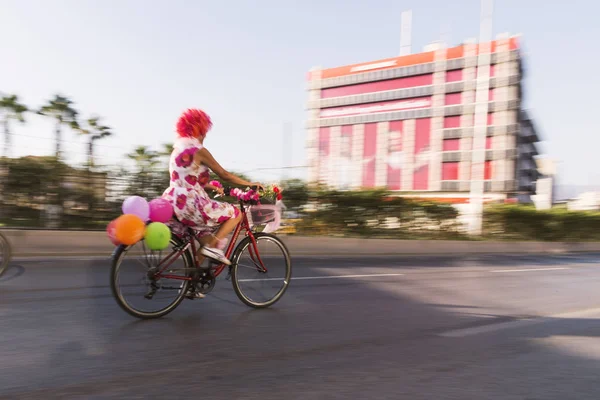 Frau auf einem Fahrrad mit Luftballons und ausgefallenen Sachen in Izmir und — Stockfoto